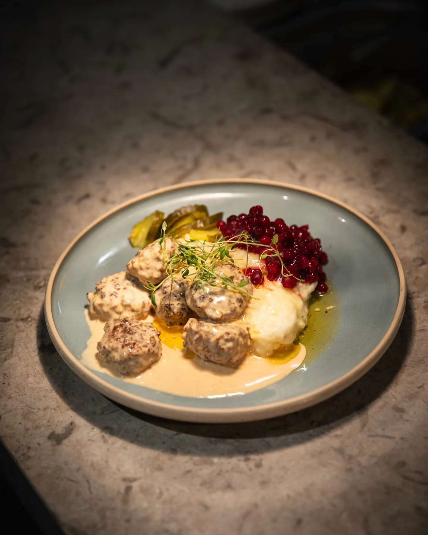 Köttbullar med gräddsås, potatismos och lingon på en tallrik